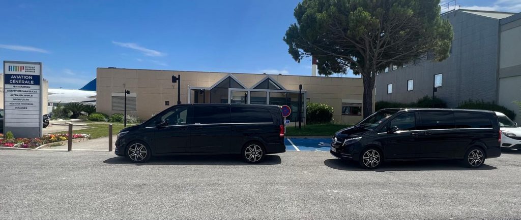 Vans Mercedes VTC stationnés devant le terminal Aviation Générale de l’aéroport Marseille Provence
